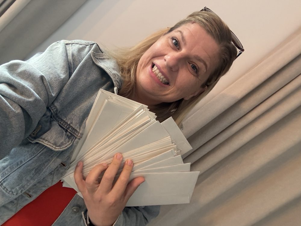 Emilie Giraud tenant une liasse d'enveloppes
